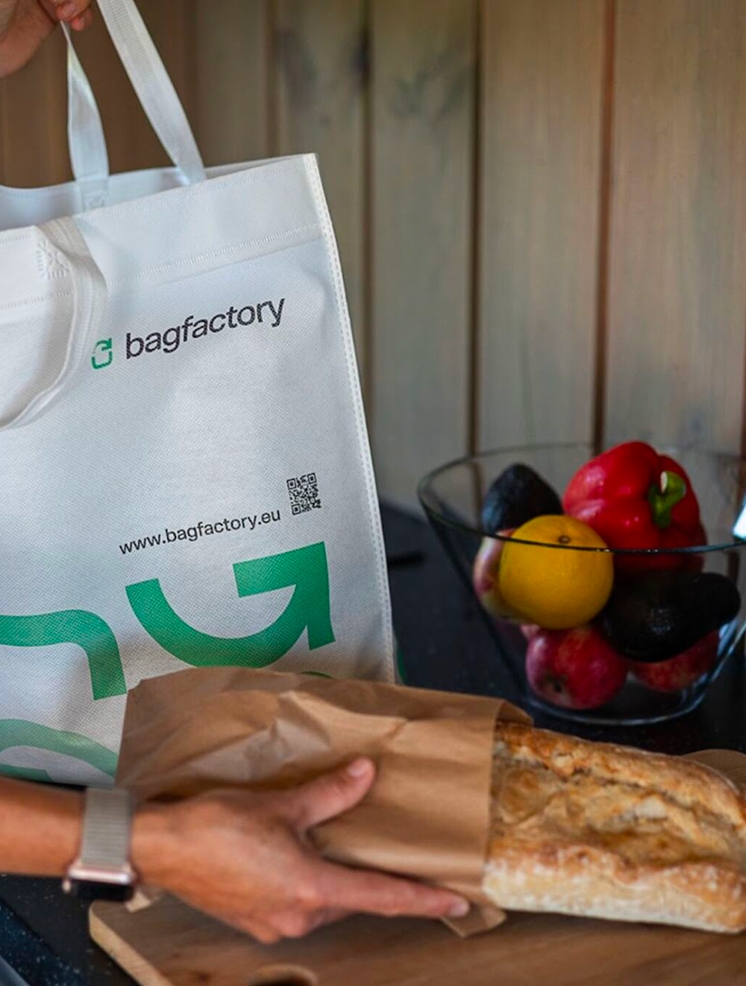 Reusable shopping bag from Bagfactory.eu next to fresh groceries and artisan bread, promoting sustainable packaging and eco-friendly lifestyle.